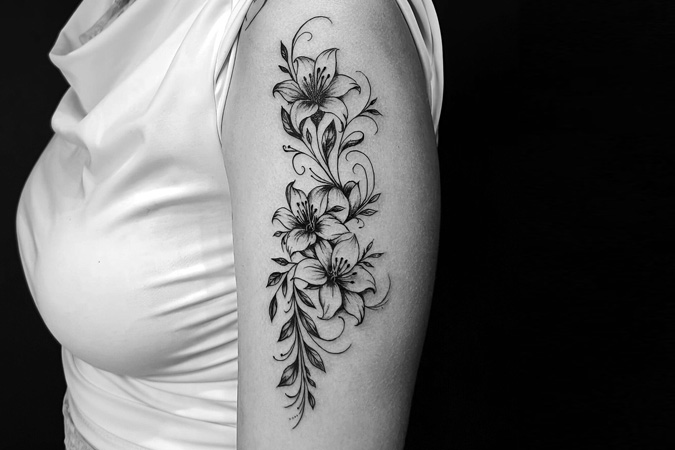 Tatuaje de lirios en brazo de mujer